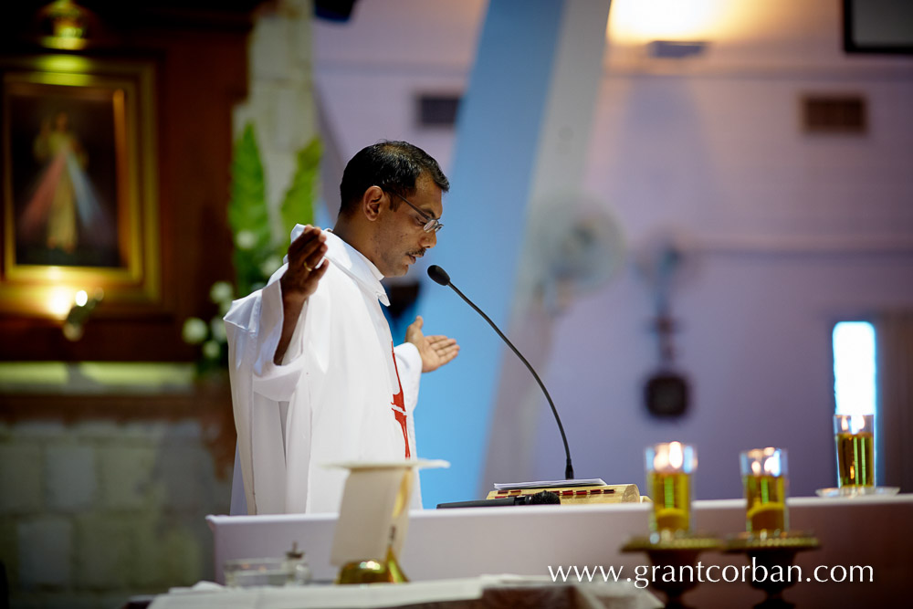 priest conducting wedding at Bride in car at wedding church of the holy spirit greenlane penang